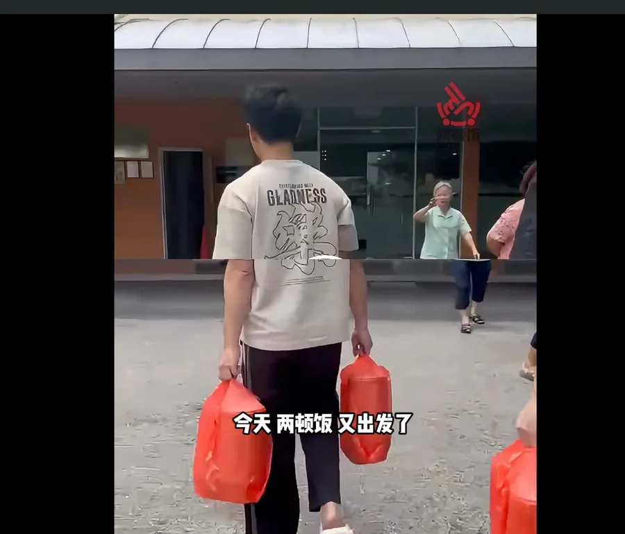 送餐人员提着两大袋饭盒走出去